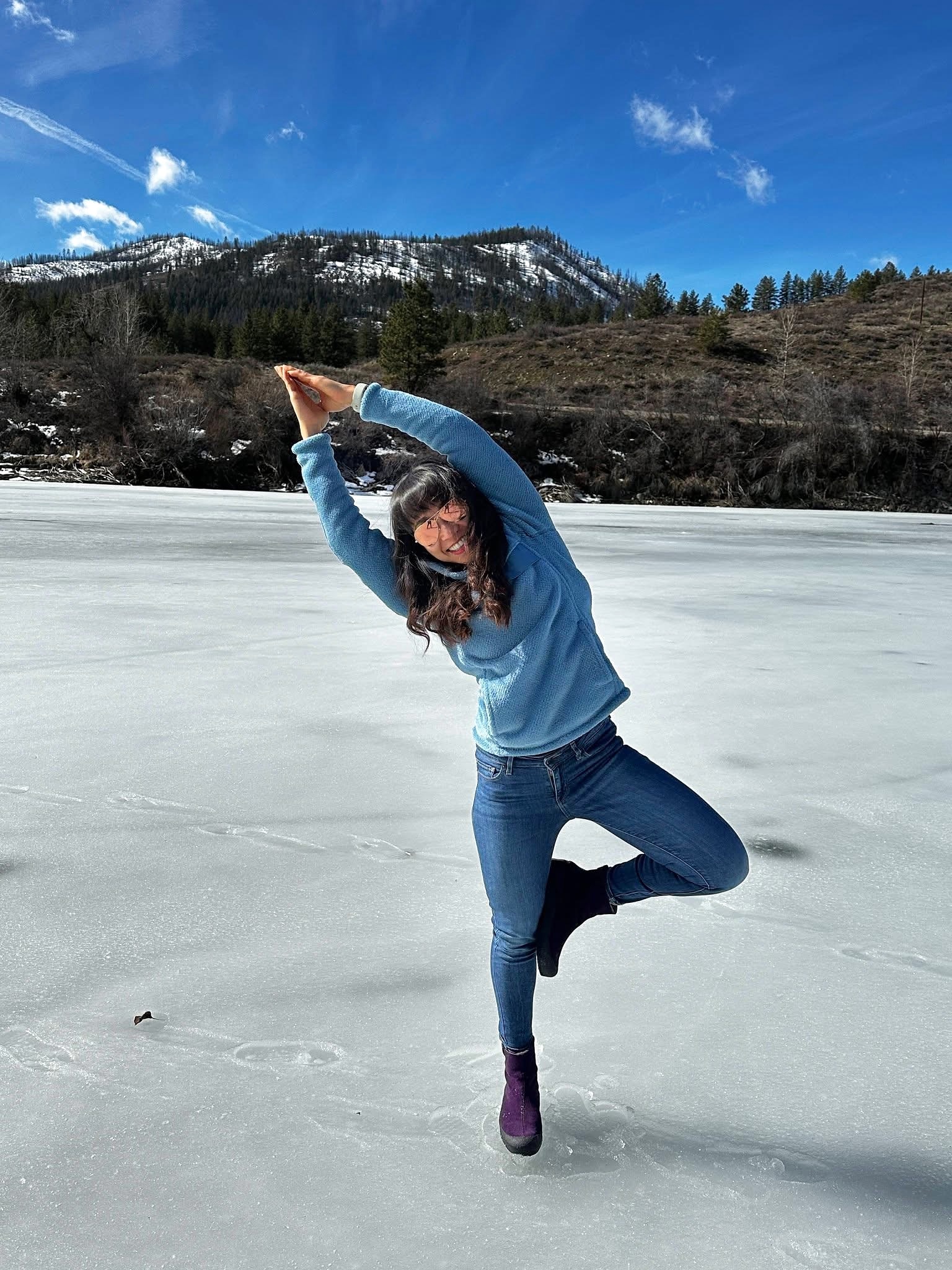 Kate balancing playfully on frozen Patterson Lake in Winthrop